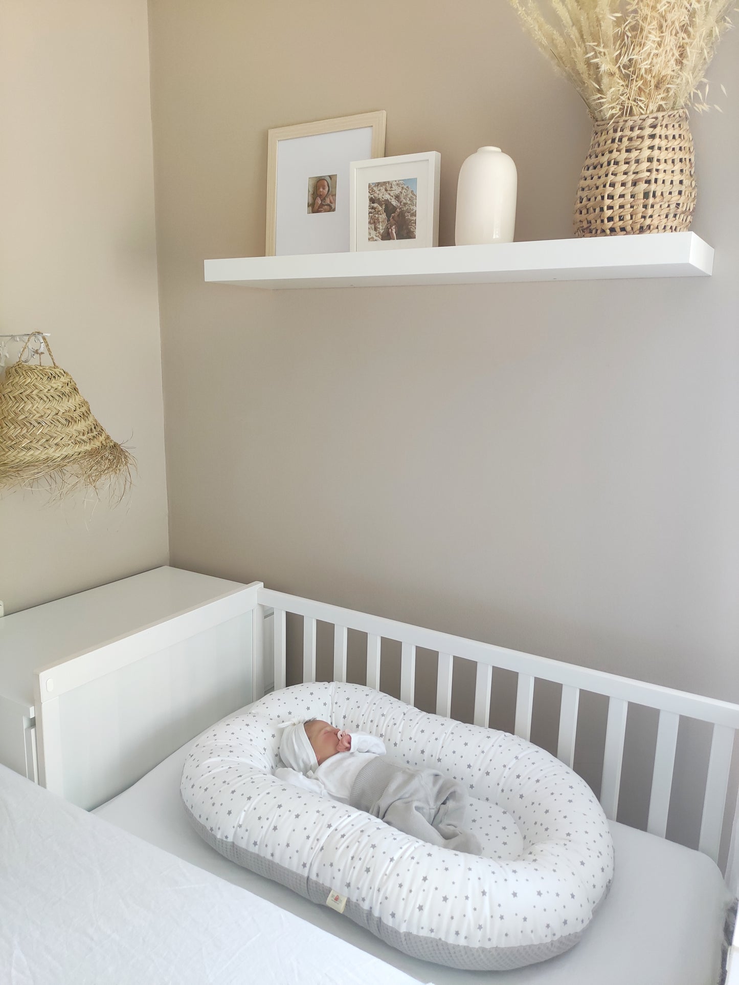 Reductor de cuna de tejido gris con bonito estampado de estrellas, ideal para brindar el apoyo y suavidad que tu bebé necesita durante su descanso.
